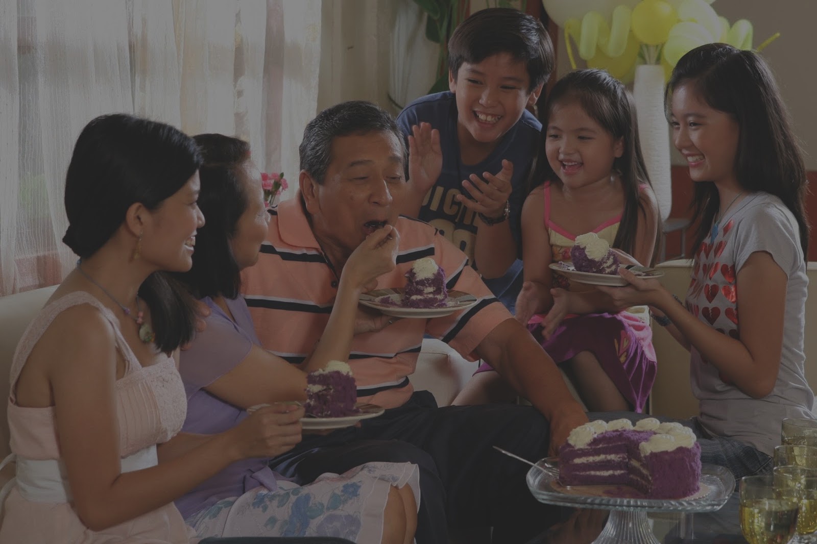 Filipino family sharing laughs and delicious ube cake.